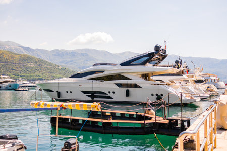 Luxury yacht docked in scenic marina on a sunny coastal day. Summer travel, elite leisure, and the lifestyle of Mediterranean seaside tourism.の写真素材