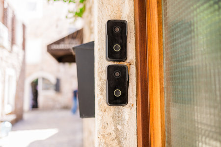 Smart doorbells on old stone entryway. Urban security, smart technology, and modern living in...