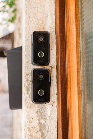 Smart doorbells on old stone entryway. Urban security, smart technology, and modern living in...