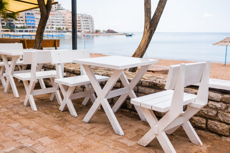 Outdoor cafe or restaurant with sea view and empty chairs. Coastal relaxation, summer tourism, and beachfront dining in the Mediterranean region.の写真素材