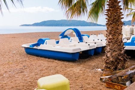 Blue and white pedal boats on shore. Summer recreation, water sports, and tourism infrastructure close-upの写真素材