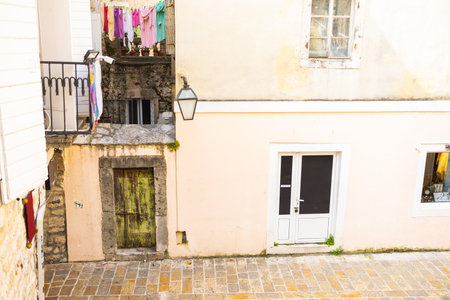 Colorful laundry above vintage doorway. Everyday charm, historical texture, and Mediterranean lifestyle.の写真素材