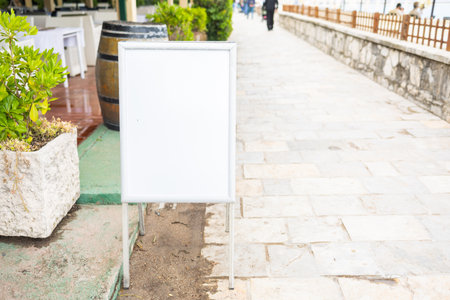 Empty blank white signboard by the seaside cafe, copy space. and mockup Coastal relaxation, vacation ambiance and summer leisure by the sea.の写真素材