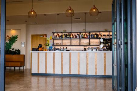 Modern bar interior with pendant lights and a wide beverage selection. Hospitality, leisure and stylish beverage service in contemporary indoor setting.の写真素材