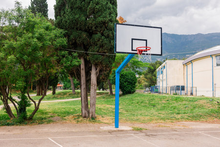 Outdoor basketball hoop in a public park. Urban recreation, sports activity, and healthy lifestyle in a community setting.の写真素材