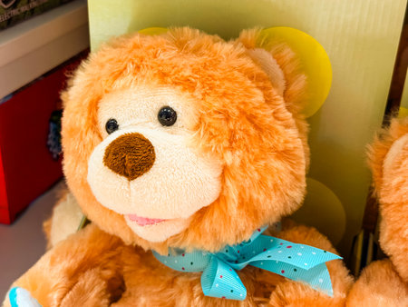 Cute plush teddy bear with blue ribbon. Childhood memories, comfort, and emotional warmth in toys and gifts.の写真素材