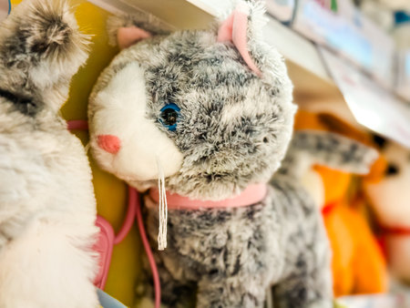 Plush cat toy with gray fur and pink collar. Nostalgia, companionship, and the playful charm of childhood memories.の写真素材