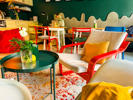 Cozy cafe interior with colorful chairs, pillows and patterned carpet. Relaxed lifestyle, social space and modern designの写真素材
