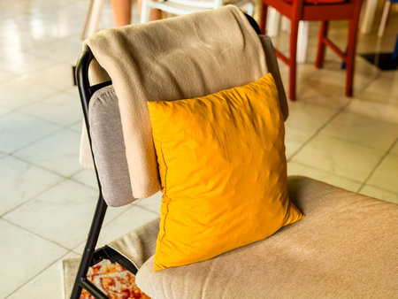 A chair with a yellow cushion and a beige blanket in the interior. A combination of warmth and...