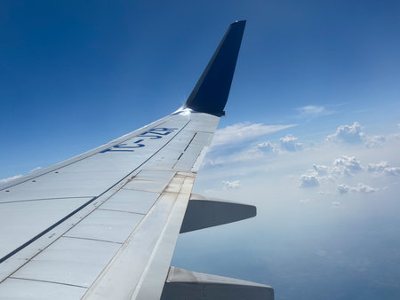 Airplane wing with winglet flying above clouds. Technology, travel, and aviation industry in modern transportation.の写真素材