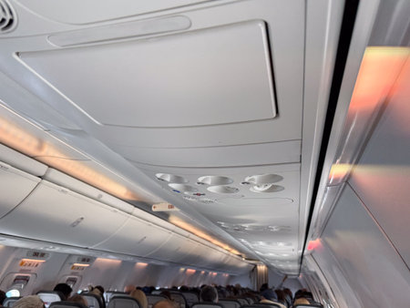 Airplane interior with passengers during flight. Travel experience, aviation transport and journey atmosphere inside the cabin.の写真素材