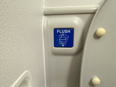 Flush button inside airplane lavatory. Aviation design, hygiene, and passenger facilities onboard.の写真素材