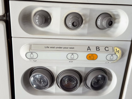 Closeup of airplane cabin panel with air vents and light controls. Passenger service and aviation...