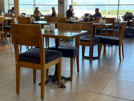 Wooden tables and chairs in a bright cafe interior. Socialization, leisure and human connection in...