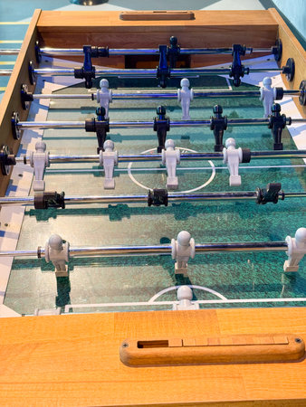 Close-up of table football game with miniature players and rods. Representation of sport, leisure,...