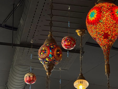 Hanging mosaic lanterns with red star patterns glowing warmly in interior. Folk craft, cultural...