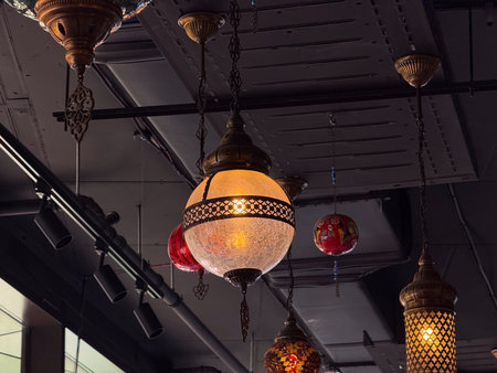 Hanging lanterns with colorful mosaic glass and brass frames glowing warmly. Traditional craft,...