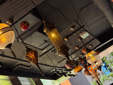 Hanging mosaic lanterns with red star patterns glowing warmly in interior. Folk craft, cultural heritage, and artistic tradition symbolizing atmosphere, hospitality, and decoration.の写真素材