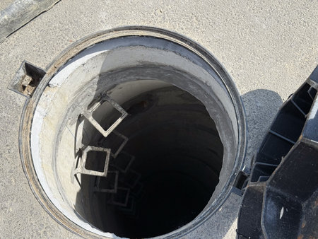 View of open manhole. Urban engineering, construction, and risk management.
