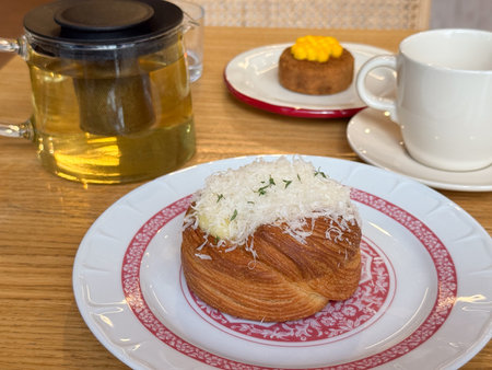 Shepherds pie with grated cheese served on patterned plate with tea. Dining lifestyle, bakery...