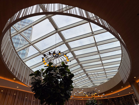 Modern glass ceiling structure in urban architecture. Reflection on transparency, geometry, and natural light as symbols of openness, innovation, and spatial harmony.の写真素材