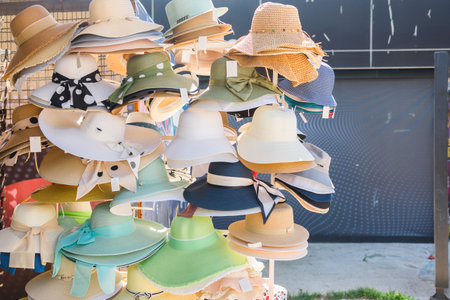 Colorful sun hats on a street market. Fashion accessories, vacation shopping, and summer style inspiration in a coastal town.の写真素材
