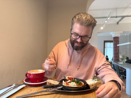 Man dining alone in cafe with breakfast. Morning calm, slow living and appreciation of simple...