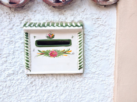 Traditional ceramic mailbox on white wall in Tenerife. Spanish craftsmanship, folk art, and Mediterranean heritage reflecting island identity.の写真素材