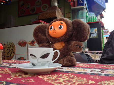Toy with coffee cup in a street cafe. Playfulness, travel charm, and the cozy fusion of cultures in everyday life.の写真素材