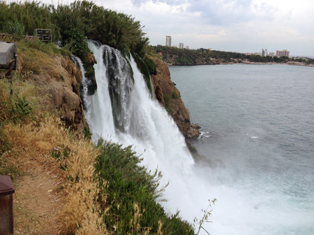 Duden Waterfall crashes down rocky cliff near city in Turkey in the province of Antalya . Force, motion, gravity, solitude, erosion, time, connection, awe, freedom, and escape from urban routineの写真素材