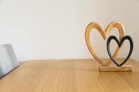 Two hearts on wooden table. Affection, togetherness, and intimate harmony of shared home life.の写真素材