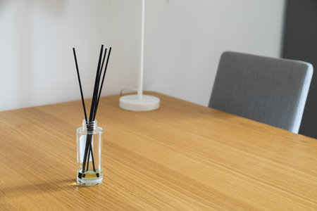 Reed diffuser on wooden table. Scent, calmness, and home fragrance in peaceful minimalist space. Copy spaceの写真素材
