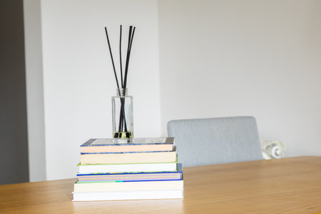 Reed diffuser on books. Knowledge, relaxation, and harmony of mind in home interior. Copy spaceの写真素材