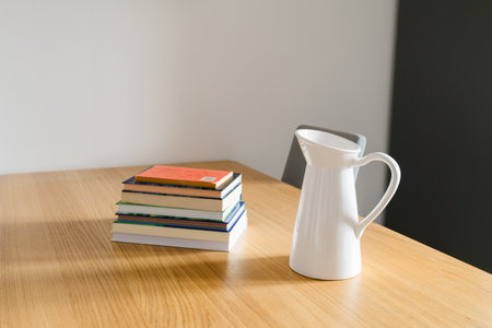 Books and jug on wooden table. Tranquility, home simplicity, and quiet balance of daily life. Copy spaceの写真素材