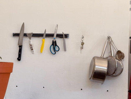 Kitchen wall with knives, scissors, and utensils. Order, functionality, and minimal modern workspace aesthetic.の写真素材