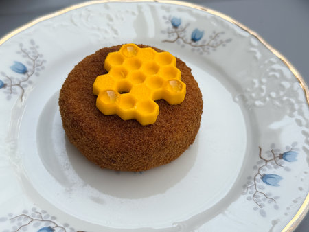 Closeup of honey-inspired dessert with yellow decoration. Confectionery art, patisserie elegance,...