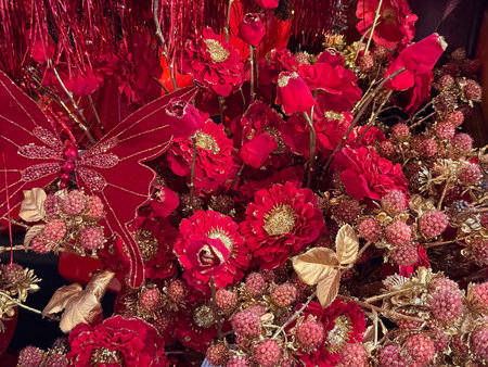 Red flowers, berries and butterfly decor covered with gold glitter in holiday display. Christmas luxury, winter floral ornament, festive arrangement and rich seasonal atmosphereの写真素材