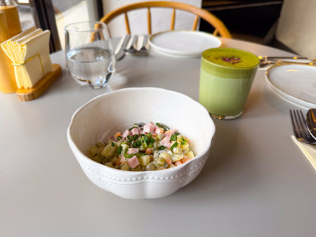 Olivier salad and matcha latte on a cafe table. Cozy lunch time, comfort food and slow lifestyle...
