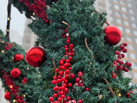 Close-up of Christmas tree branch with red berries and ornaments. Festive seasonal decor, winter celebration and traditional holiday styling.の写真素材