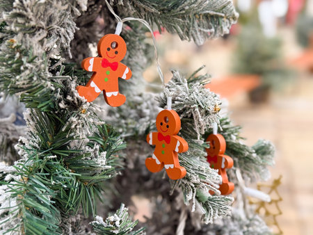 Gingerbread figure ornament on snow covered Christmas tree. Festive winter decor, playful detail and seasonal holiday atmosphereの写真素材