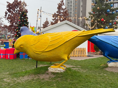 Large colorful bird sculpture displayed in outdoor winter park. Urban art installation, festive decoration, and public space designの写真素材