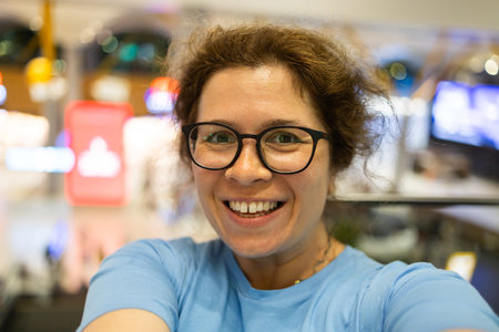 Video call portrait of excited cheerful smiling woman in spectacles taking selfie photo. Selfie and blogger conceptの写真素材