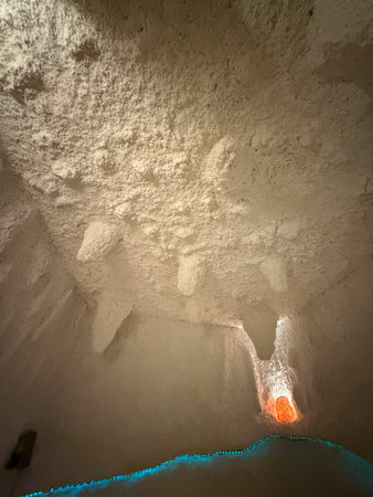 Salt cave ceiling with textured mineral formations and warm backlight. Natural therapy environment,...