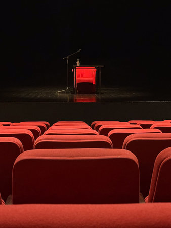 Stage with microphone and table seen from audience seats. Anticipation, art, and human expression...