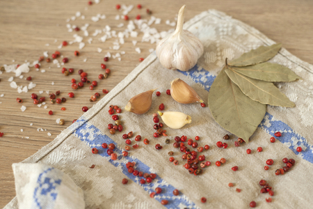 Salt and pepper with bay leaf and red pepper, white garlic on background of wood, top view of the workspace.の写真素材