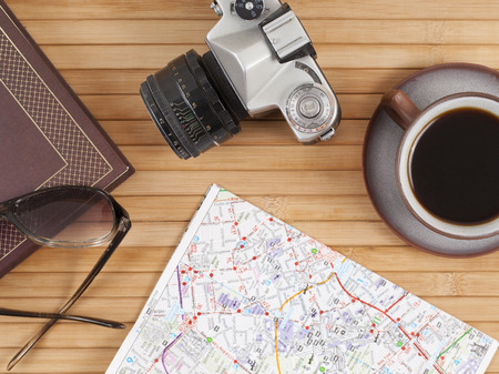 Travel preparations essentials world map cup of coffee vintage film camera notebook