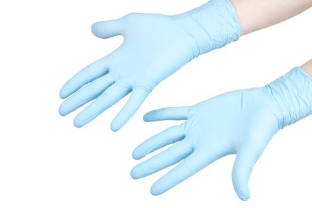 Image of a human hand wearing blue surgical gloves.の写真素材