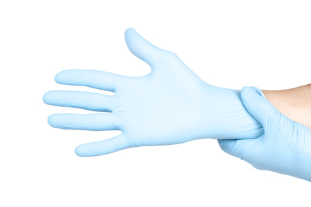 Hands of a medic in the blue latex gloves on white backgroundの写真素材
