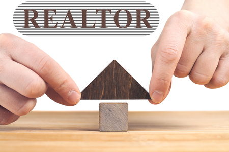 Real estate concept. Wooden house model on wooden table, white background. Realtorの写真素材