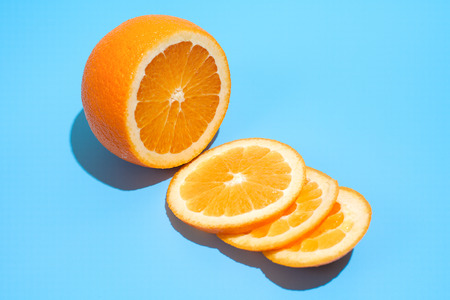 Ripe juicy delicious orange on blue background. Healthy eating and dieting conceptの写真素材